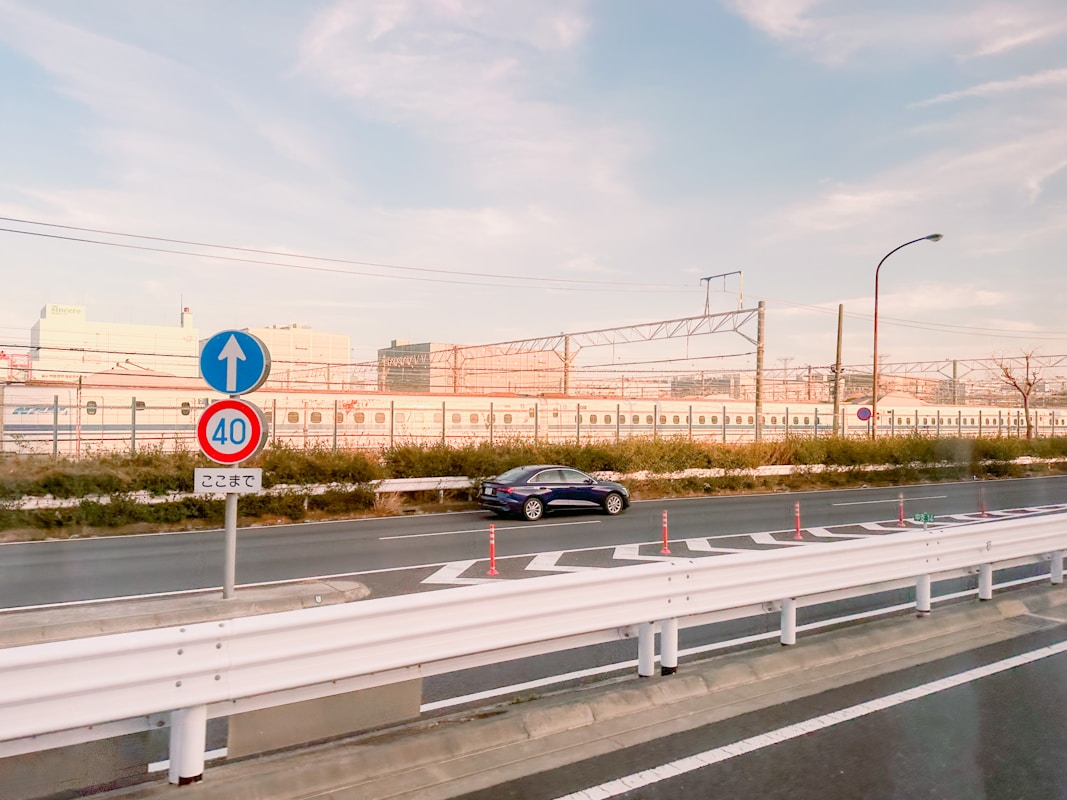 日本市區道路旁的速限標誌與行駛中的轎車