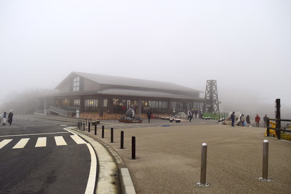 a foggy day at a train station with people walking around