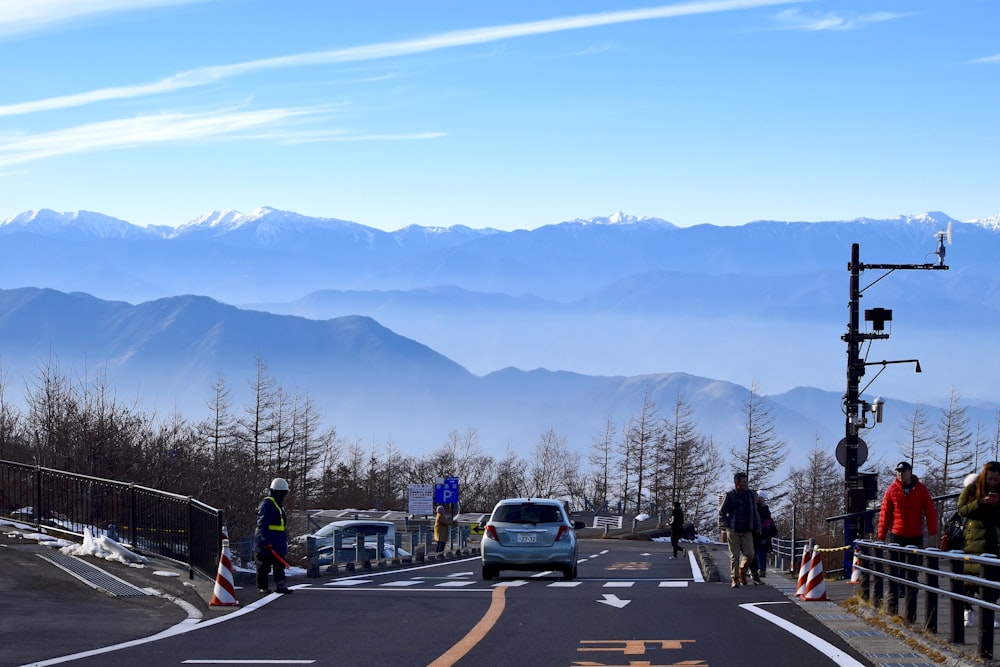 a group of people standing on the side of a road