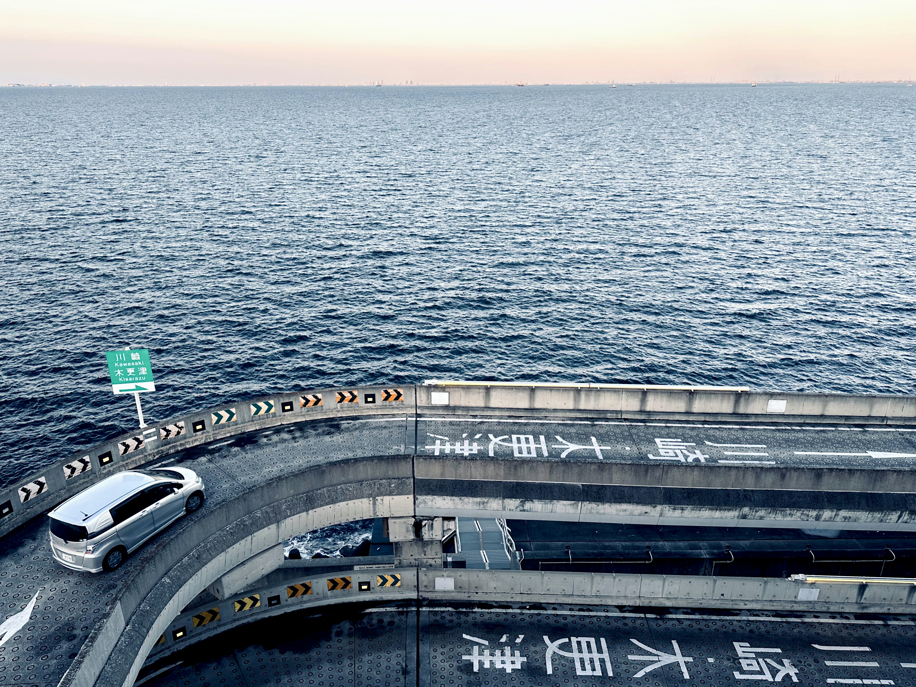 a car driving on a road next to the ocean