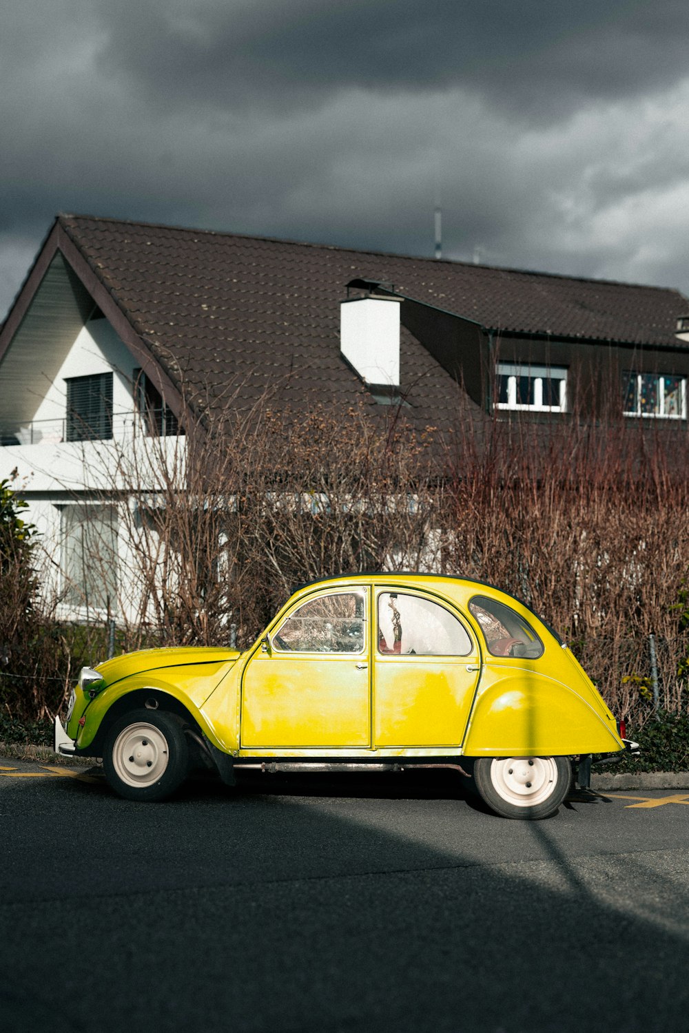 a small yellow car parked in front of a house