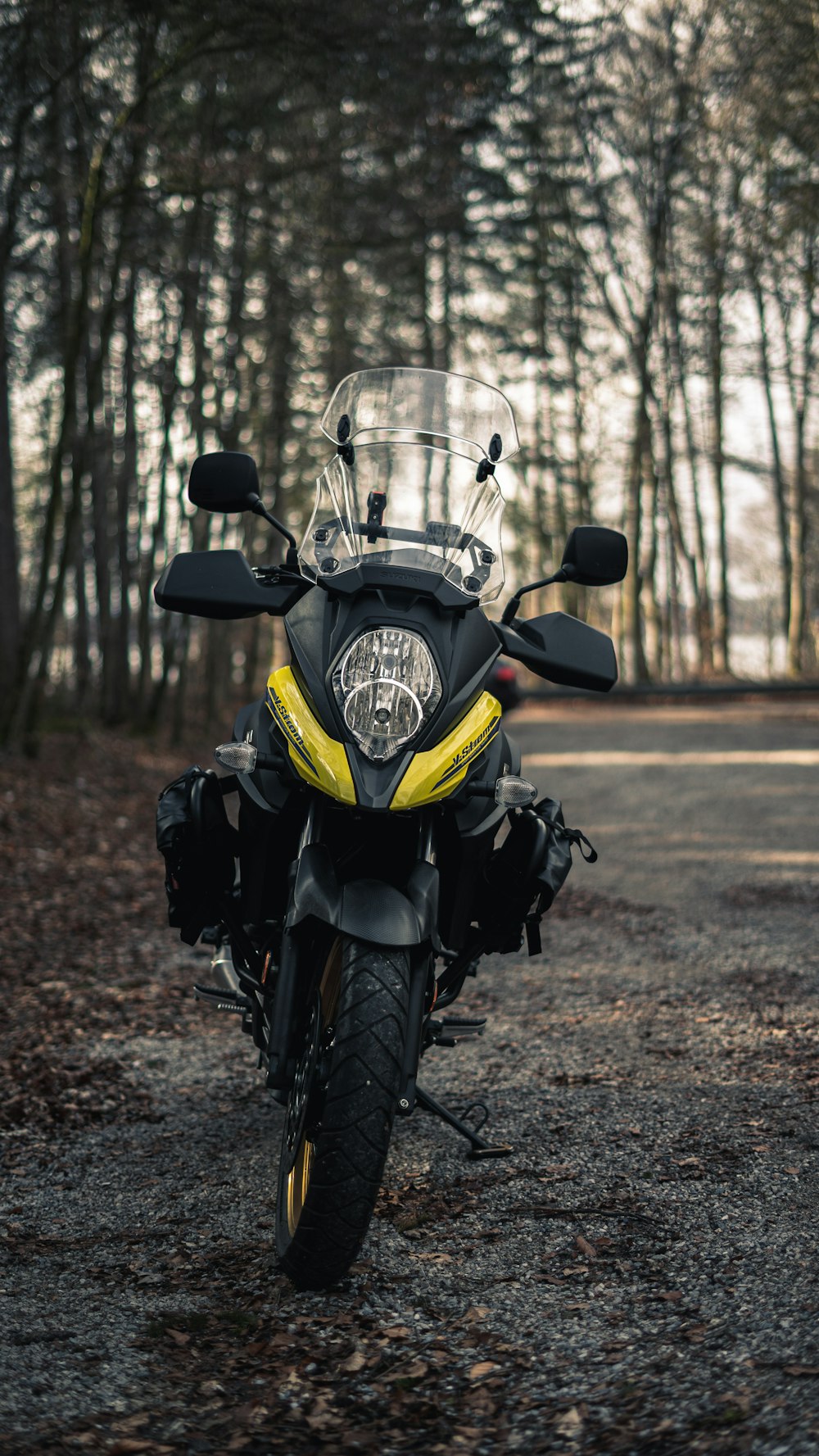 a yellow and black motorcycle parked on a dirt road