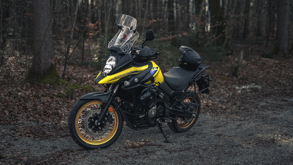 a yellow and black motorcycle parked in the woods