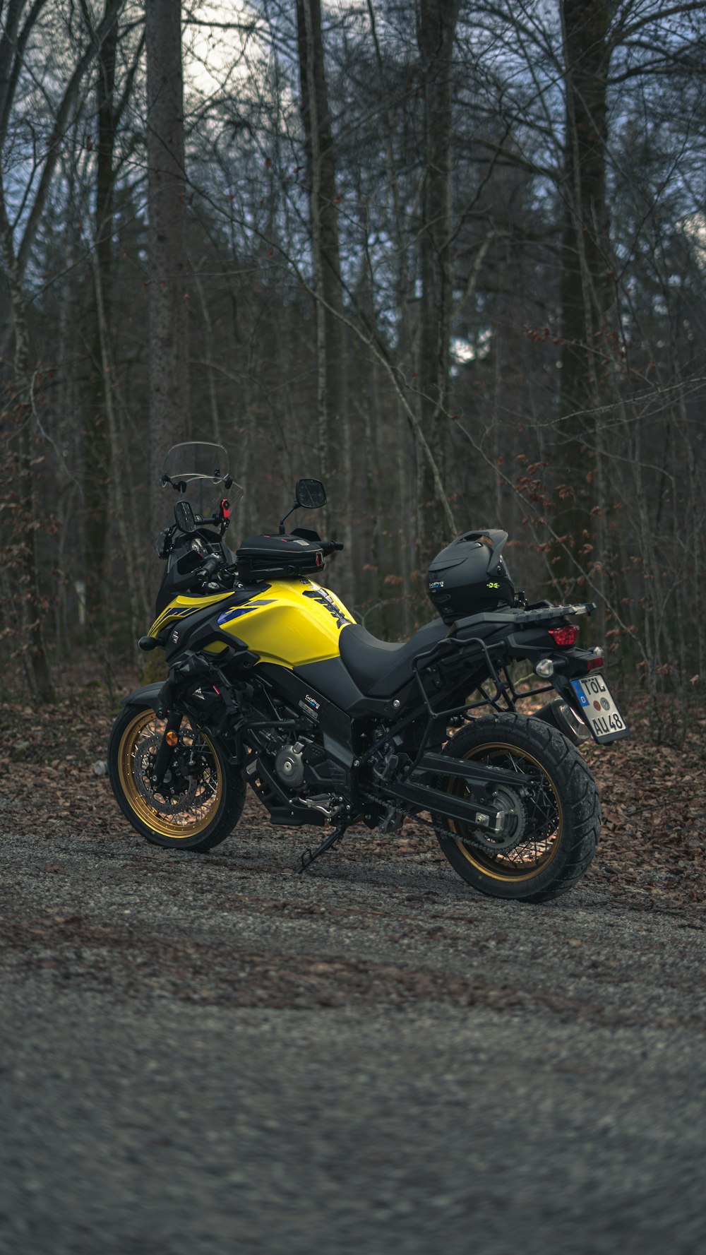 a yellow and black motorcycle parked on the side of a road