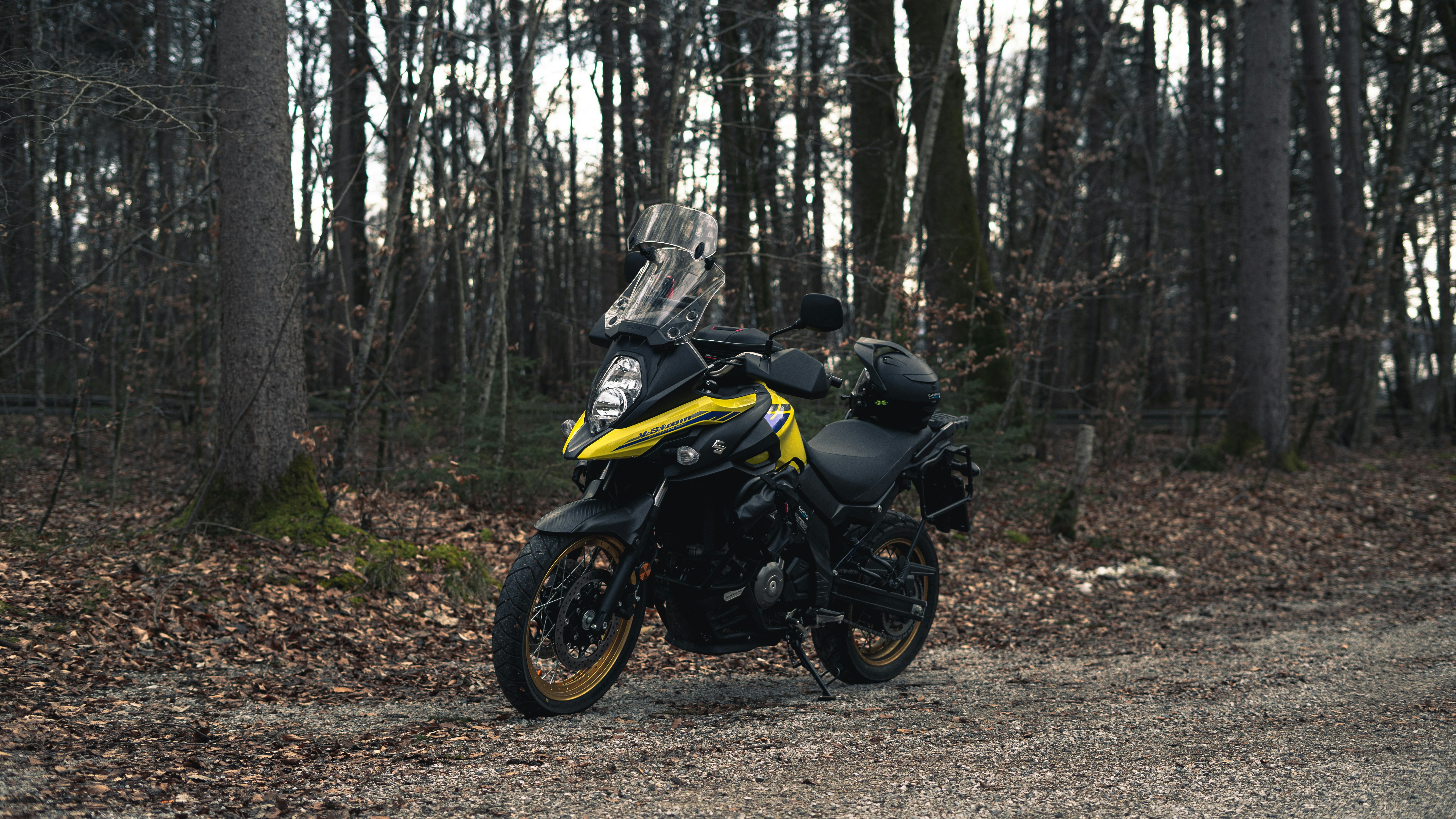 a yellow and black motorcycle parked on a dirt road