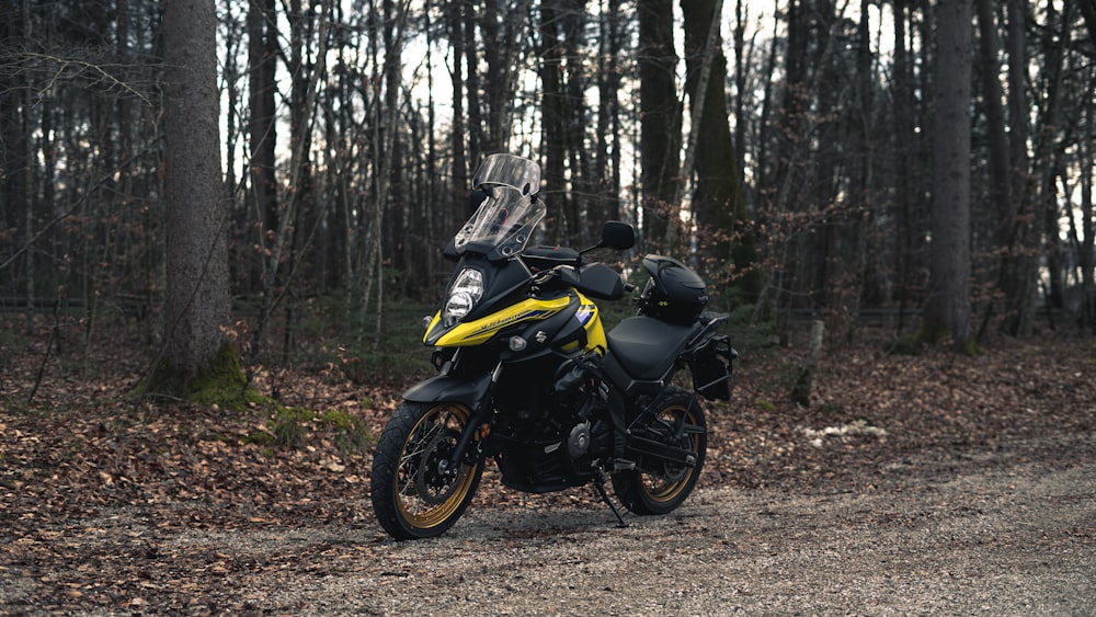 a yellow and black motorcycle parked on a dirt road