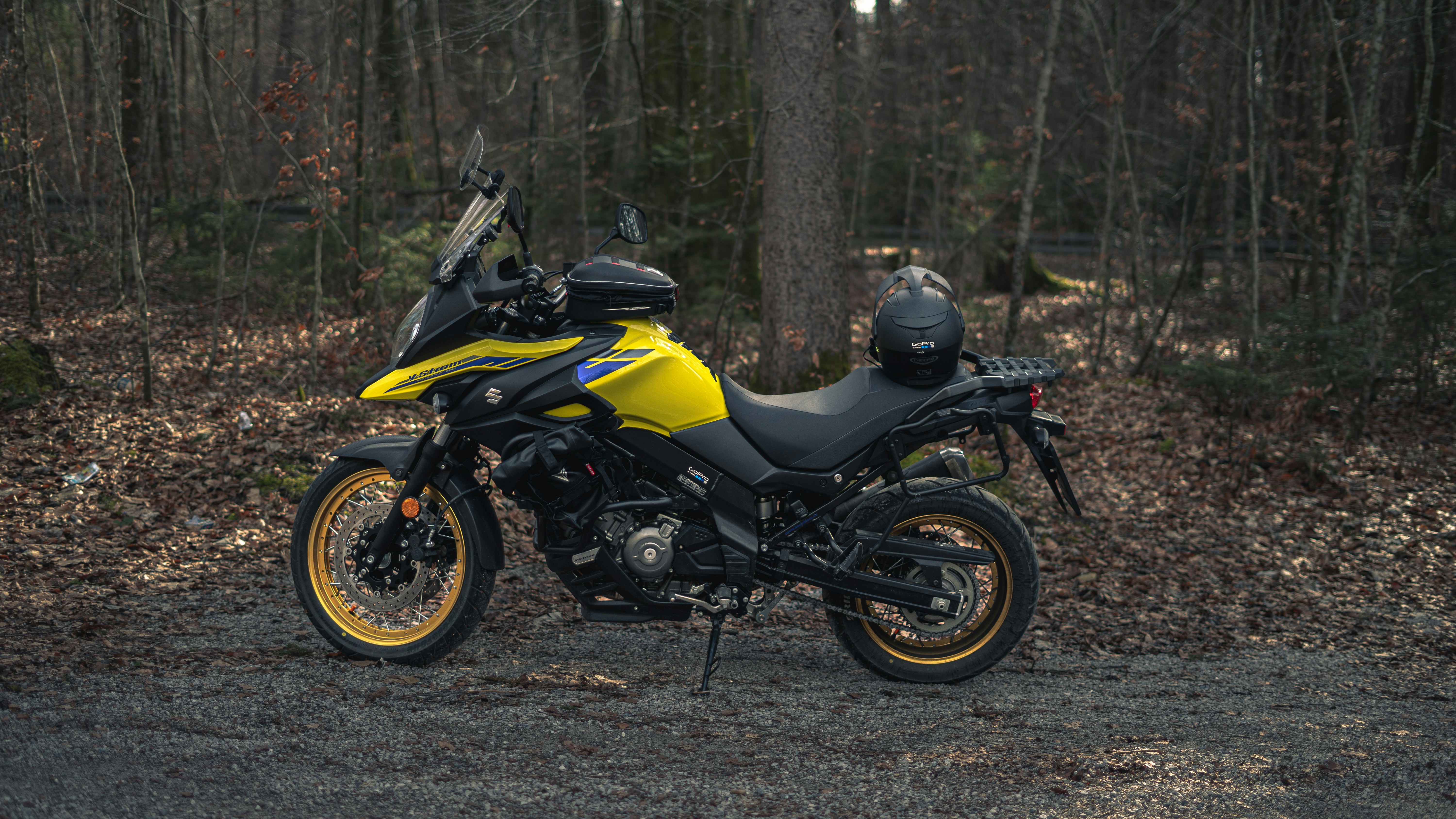 a yellow and black motorcycle parked in the woods