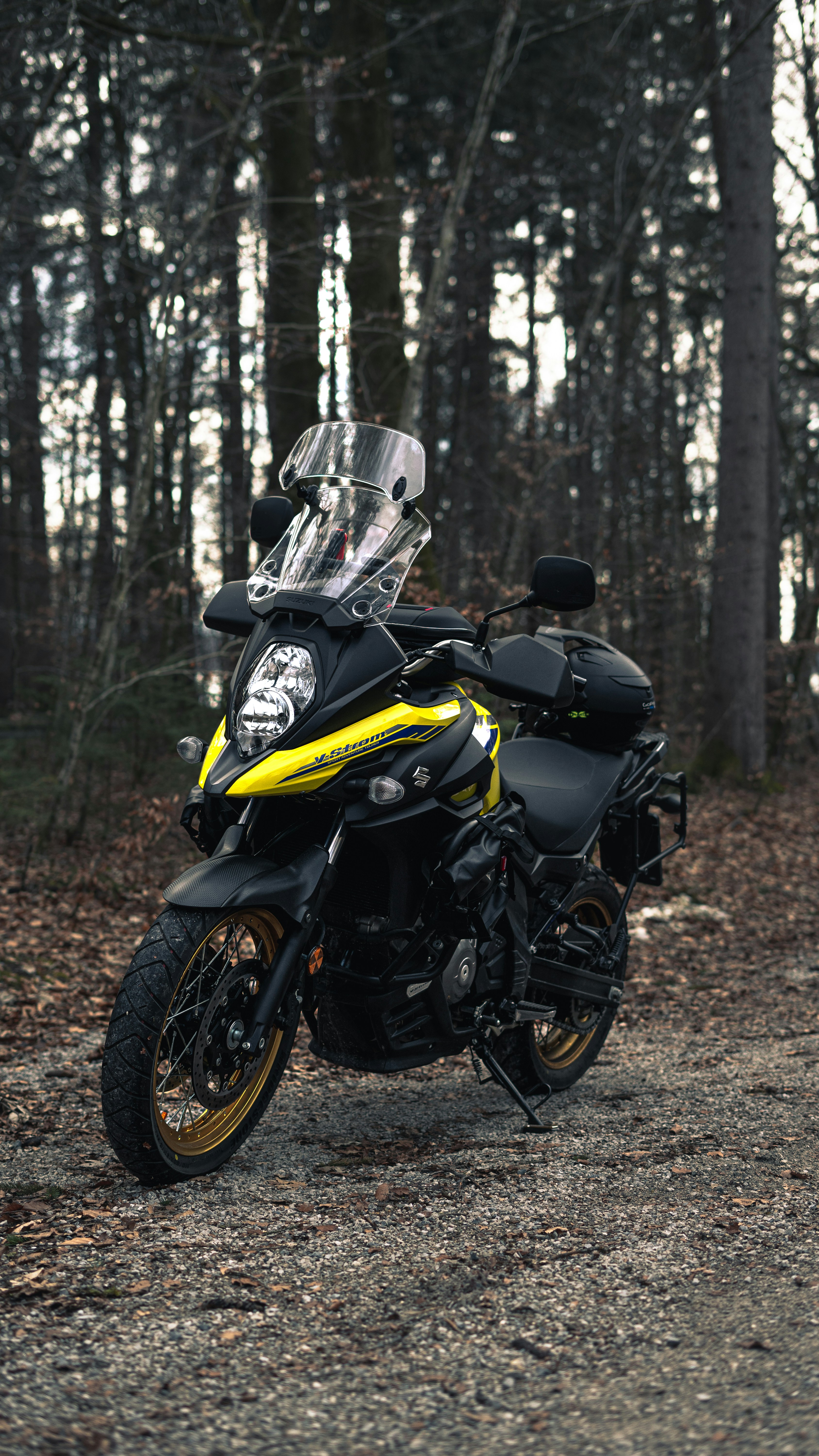 a yellow and black motorcycle parked in the woods