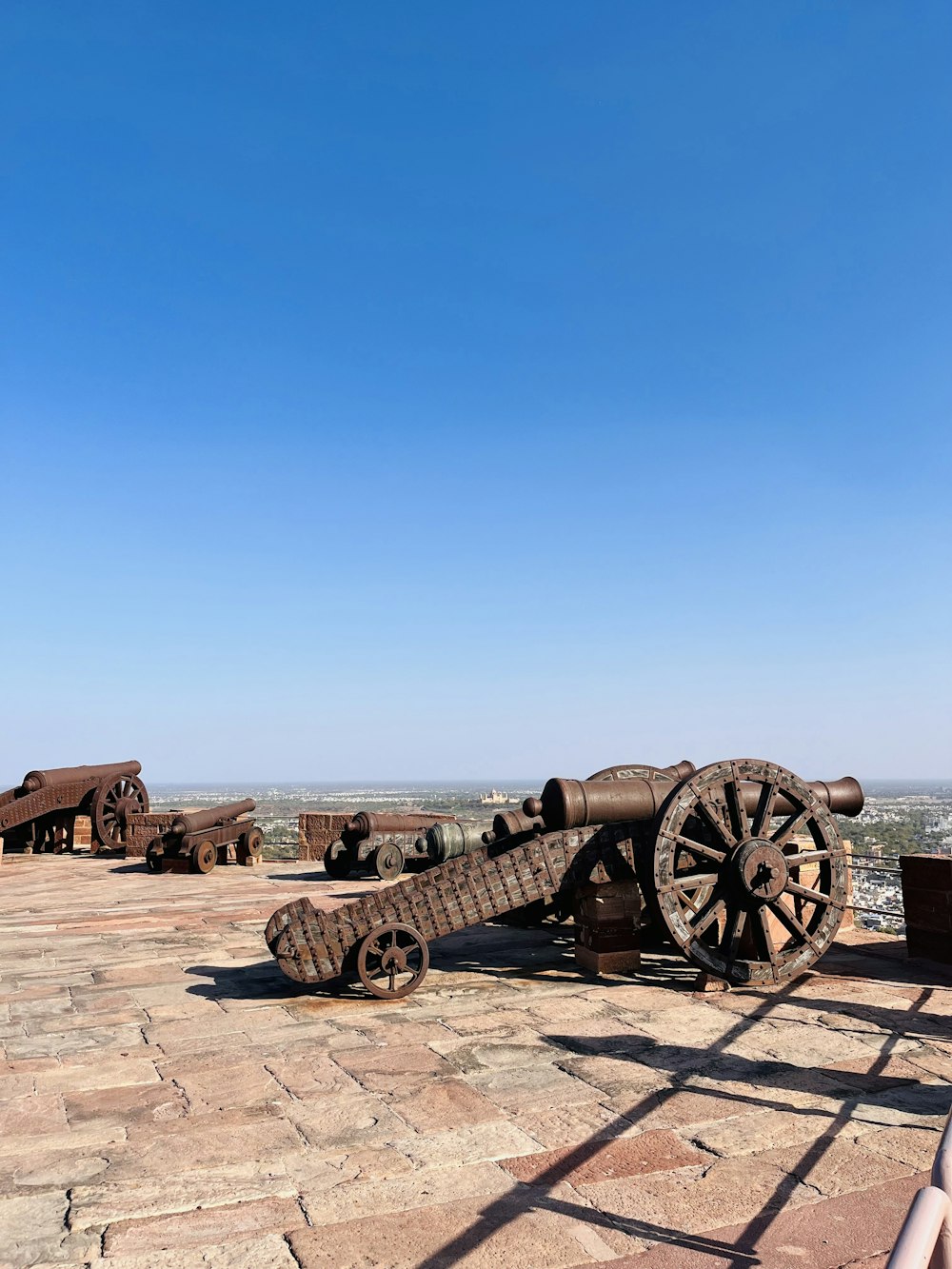 a woman standing next to a cannon on top of a stone floor