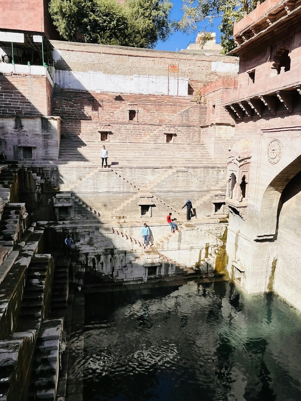 a group of people standing on the side of a river