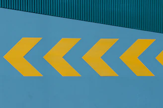 a yellow arrow painted on the side of a building