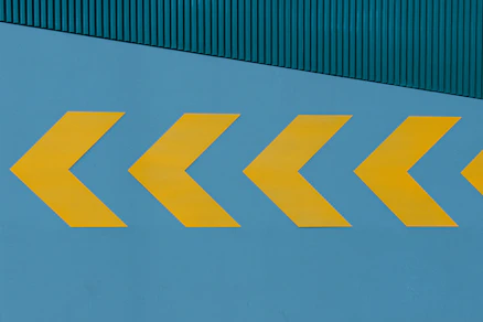 a yellow arrow painted on the side of a building