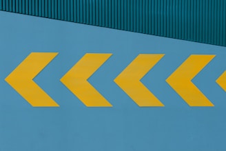a yellow arrow painted on the side of a building