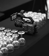 a camera and some wine glasses on a table