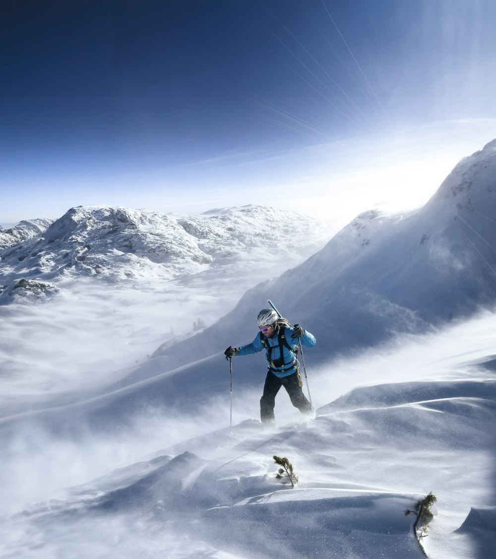 Ein Mann fährt einen verschneiten Berg hinunter