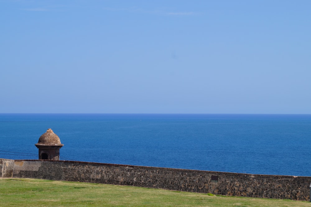 un grande specchio d'acqua seduto accanto a un muro di pietra