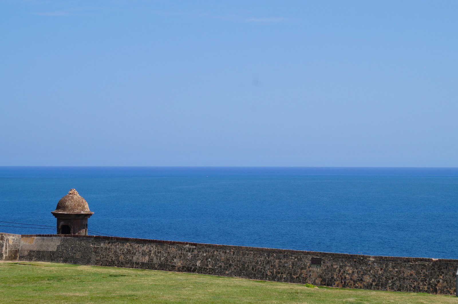 A historic San Juan fort, its stone sentry box overlooking the blue Atlantic
