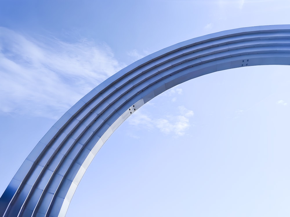 a very tall metal arch with a sky background