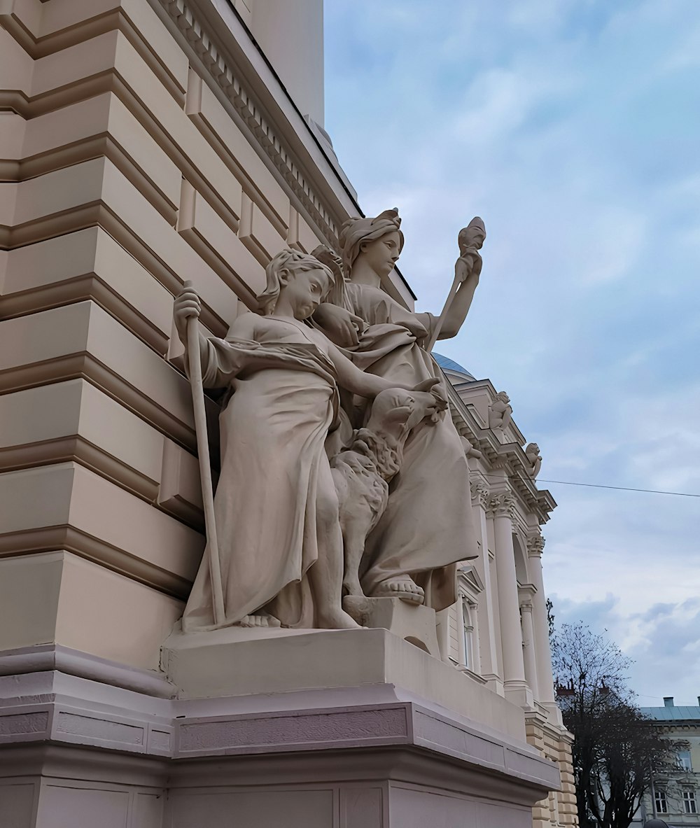 a statue of a woman holding a staff next to a building