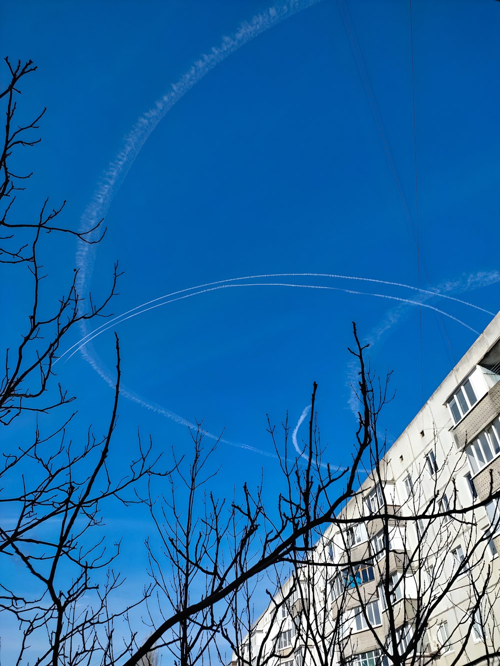 a contrail is seen in the sky over a building