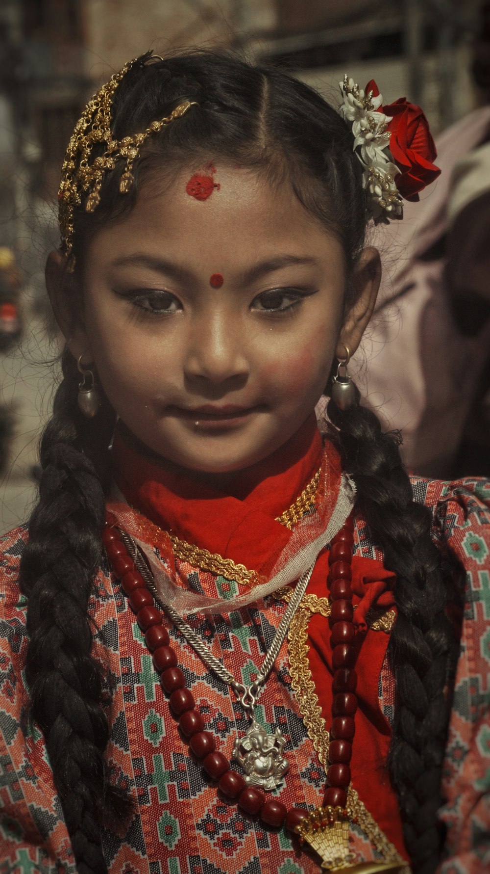 a young girl with braids and a red dress