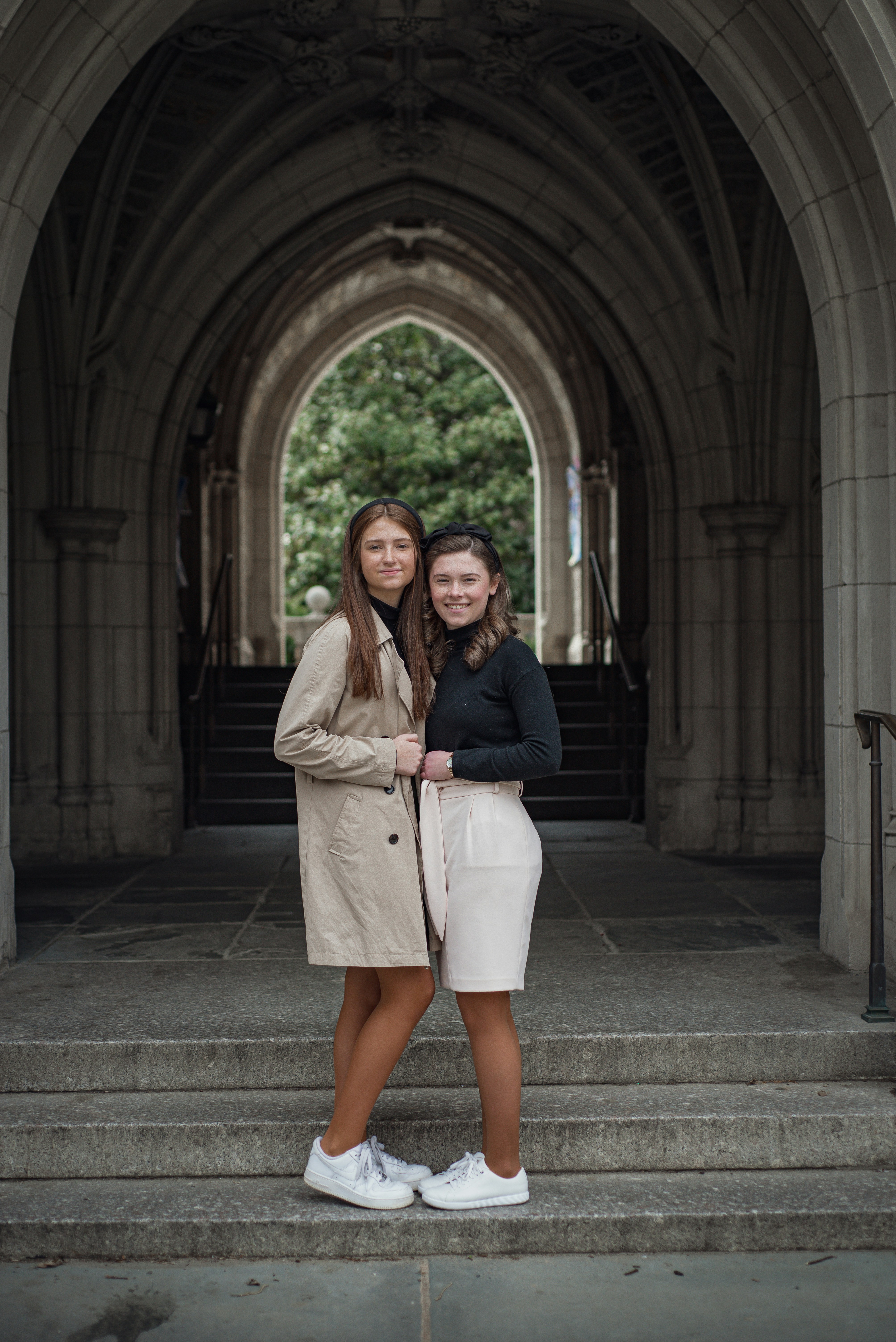 two women standing on steps in front of a building