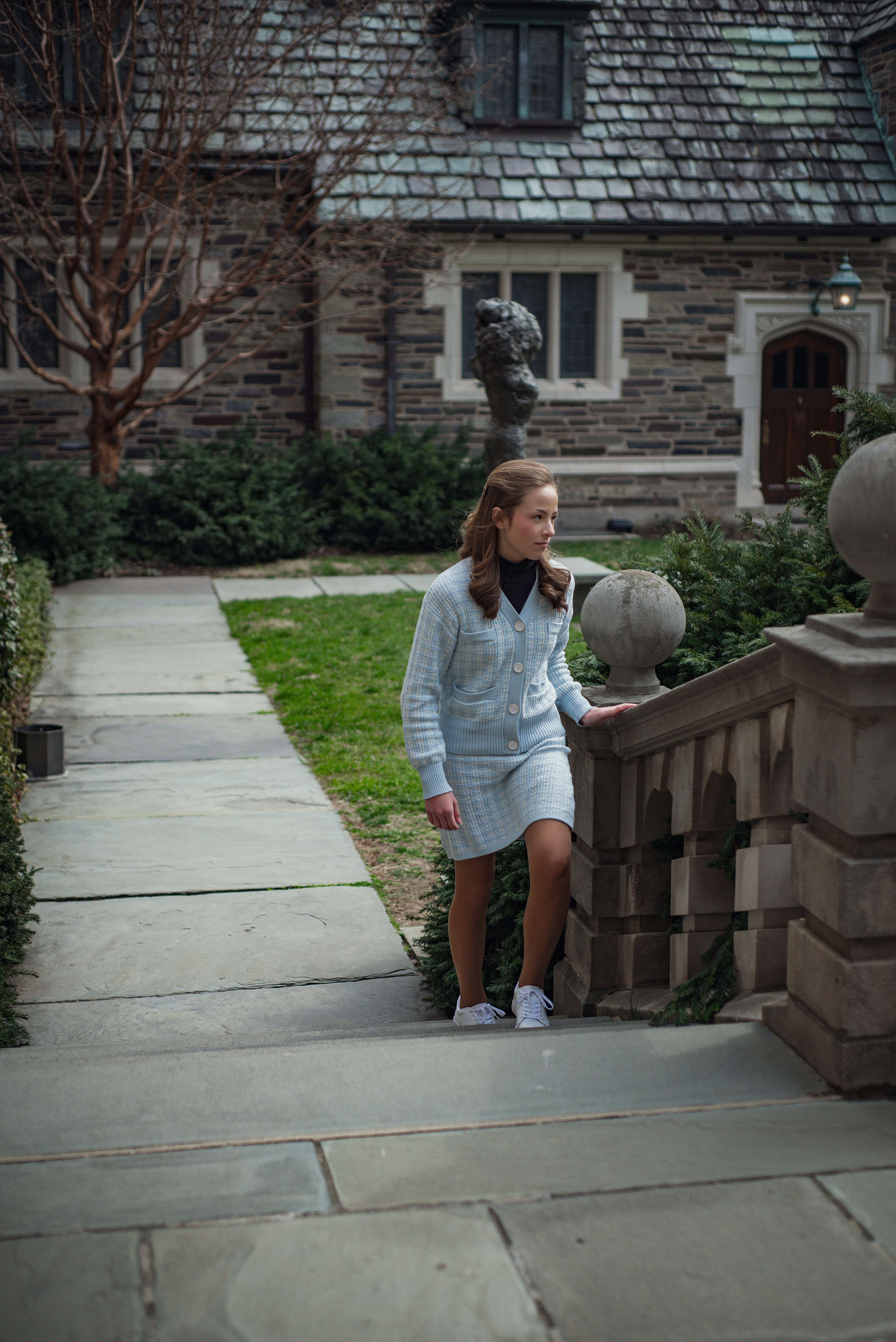 a woman in a white dress is walking down a sidewalk