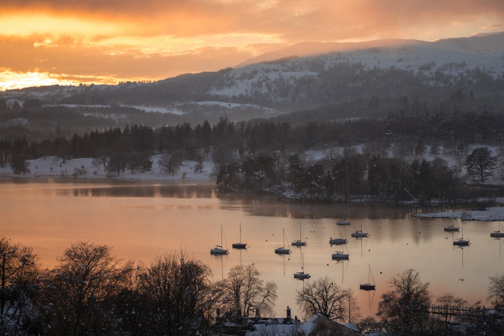 a lake surrounded by snow covered mountains and trees