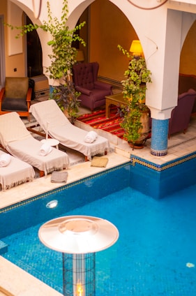 a large swimming pool with lounge chairs around it