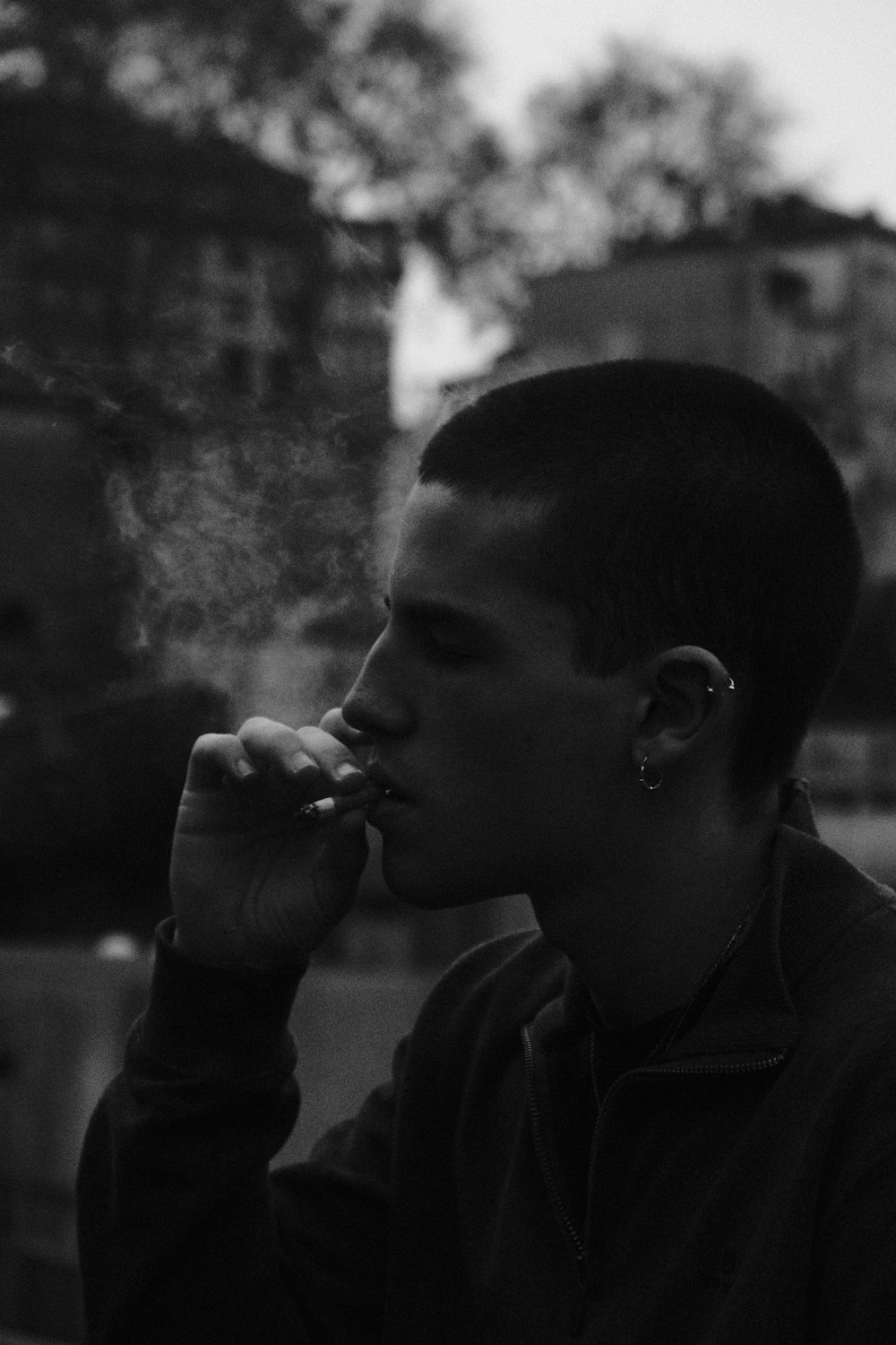 a man smoking a cigarette in a black and white photo