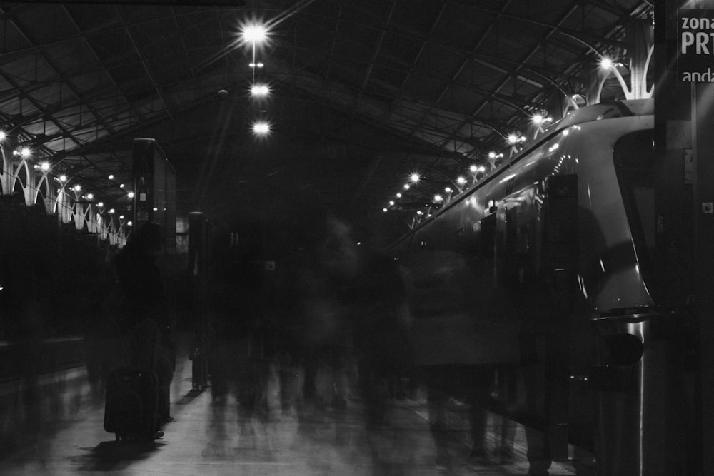 uma foto em preto e branco de pessoas em uma estação de trem