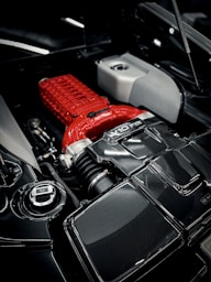 a close up of a car engine with a red engine cover