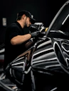 a man waxing a car in a garage