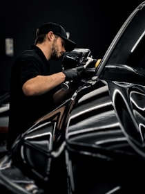 a man waxing a car in a garage