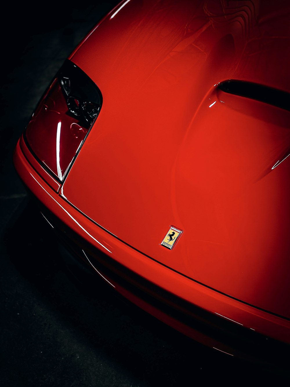 a close up of the hood of a red sports car