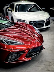 a red sports car parked next to a white sports car