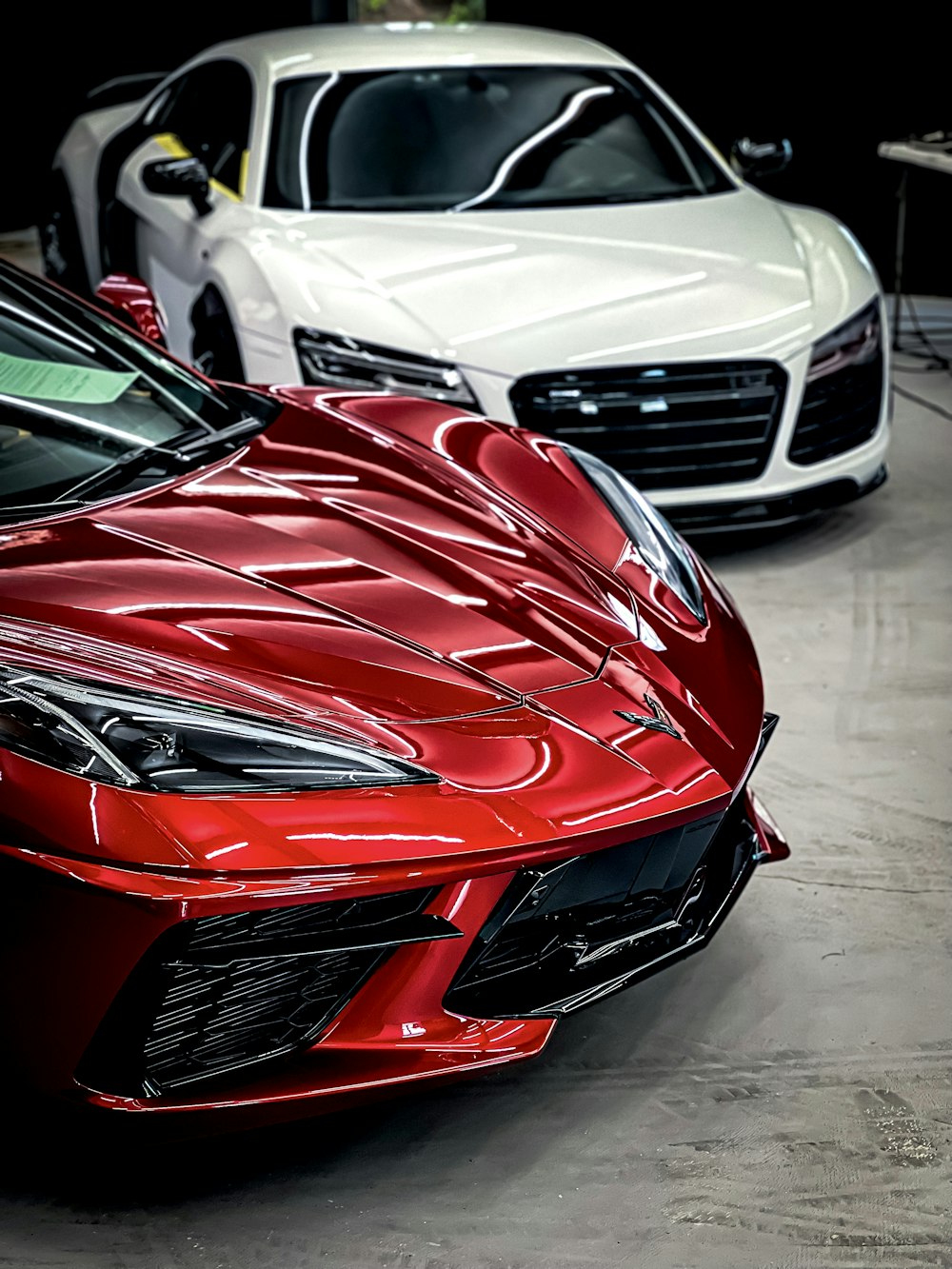 a red sports car parked next to a white sports car