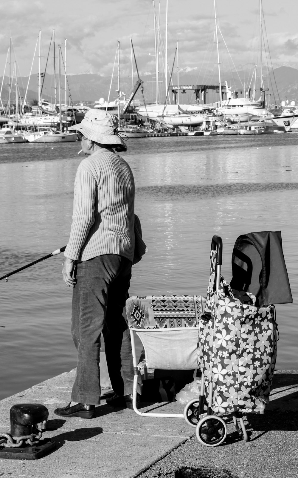 a man standing next to a baby carriage near a body of water