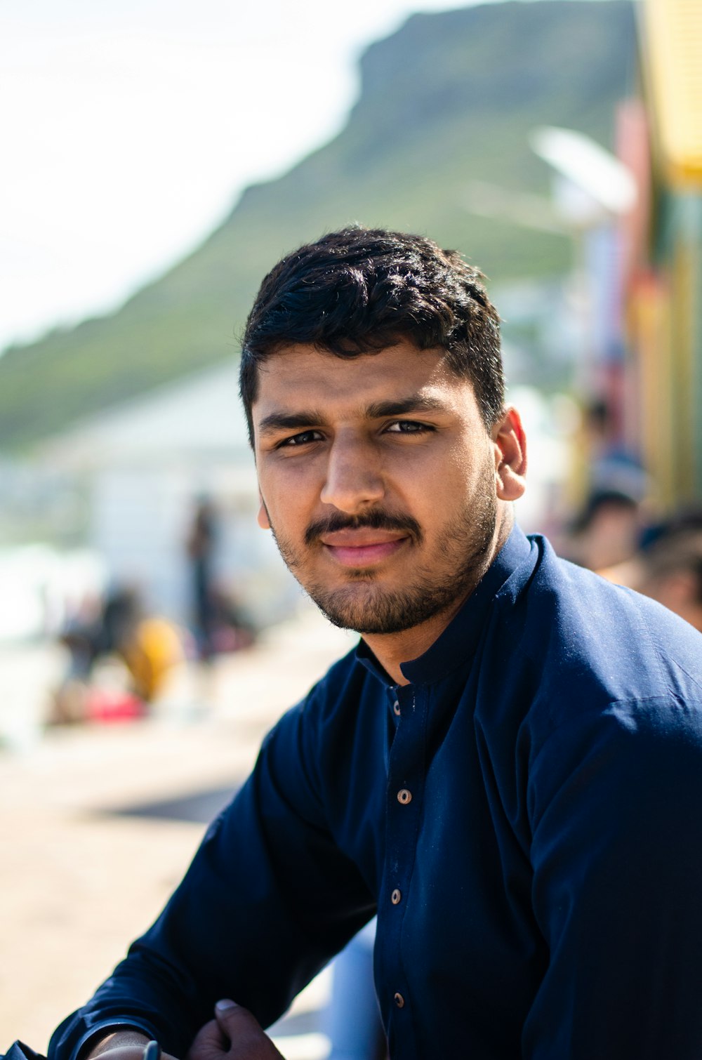 a man sitting on a bench with a mountain in the background