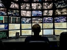 a man sitting in front of multiple monitors