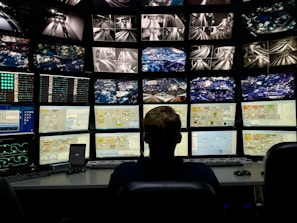 a man sitting in front of multiple monitors