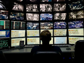 a man sitting in front of multiple monitors