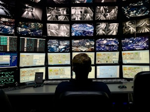 a man sitting in front of multiple monitors