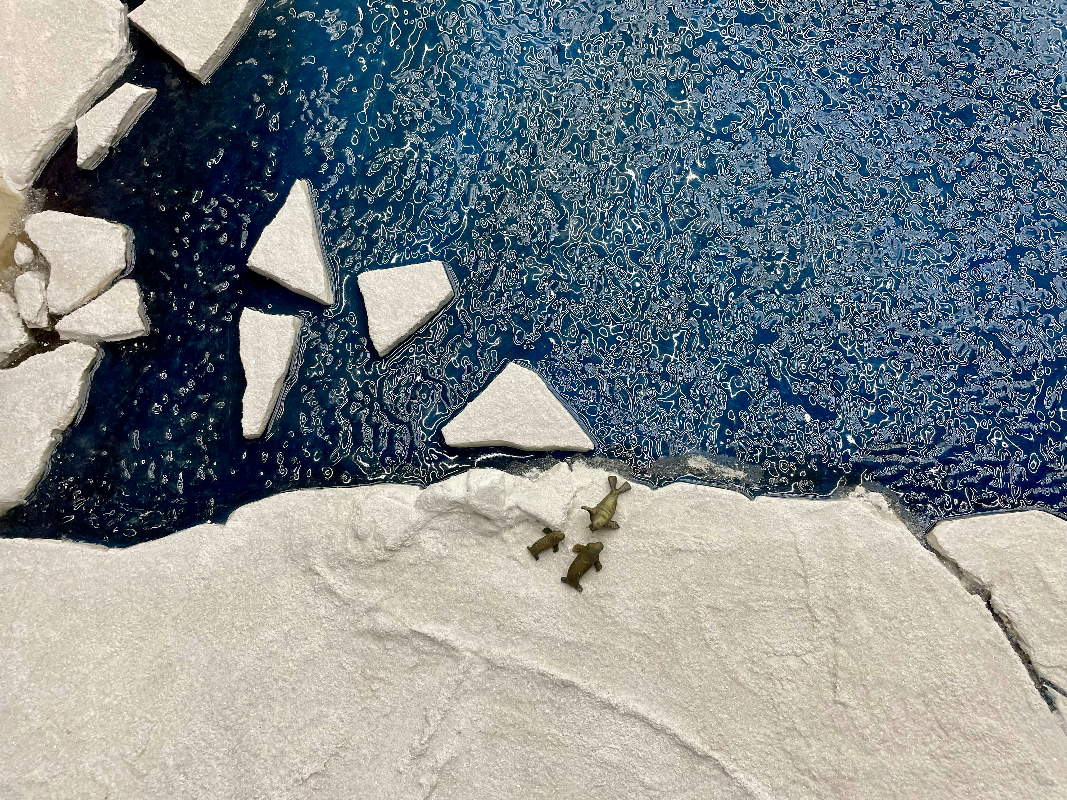 a group of icebergs floating on top of a body of water