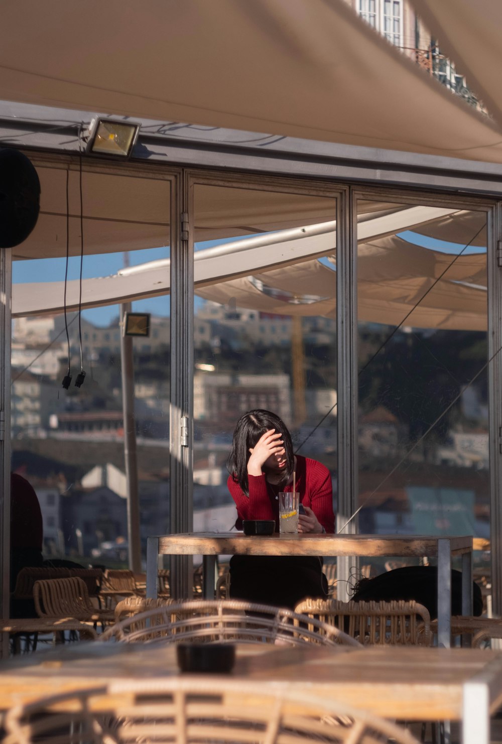 a woman sitting at a table with her head in her hands