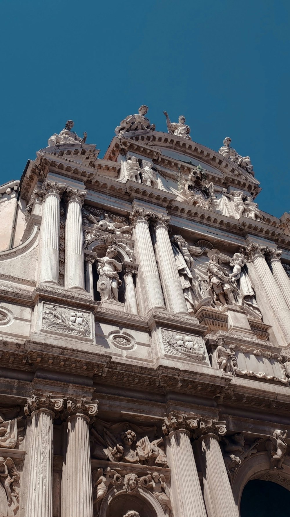 a very tall building with statues on it's sides