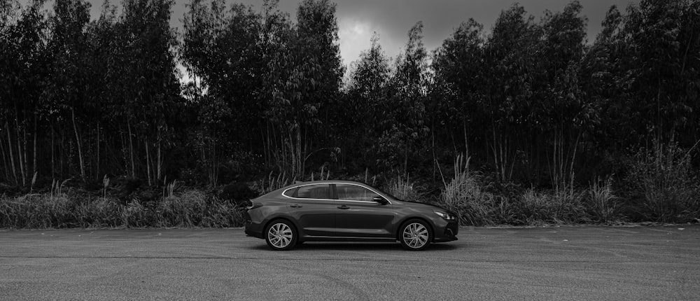 a black and white photo of a car in a parking lot