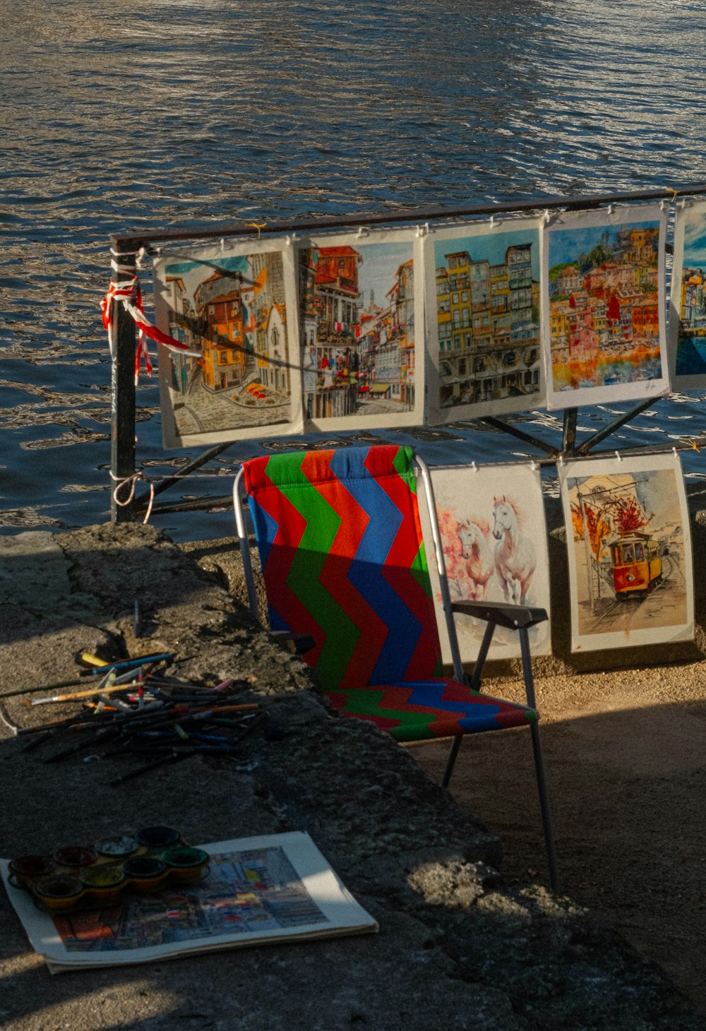 a row of chairs sitting next to a body of water