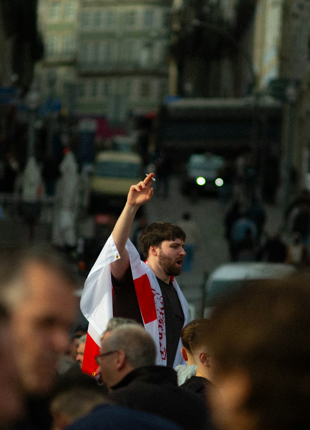 a man holding a flag in the middle of a crowded street