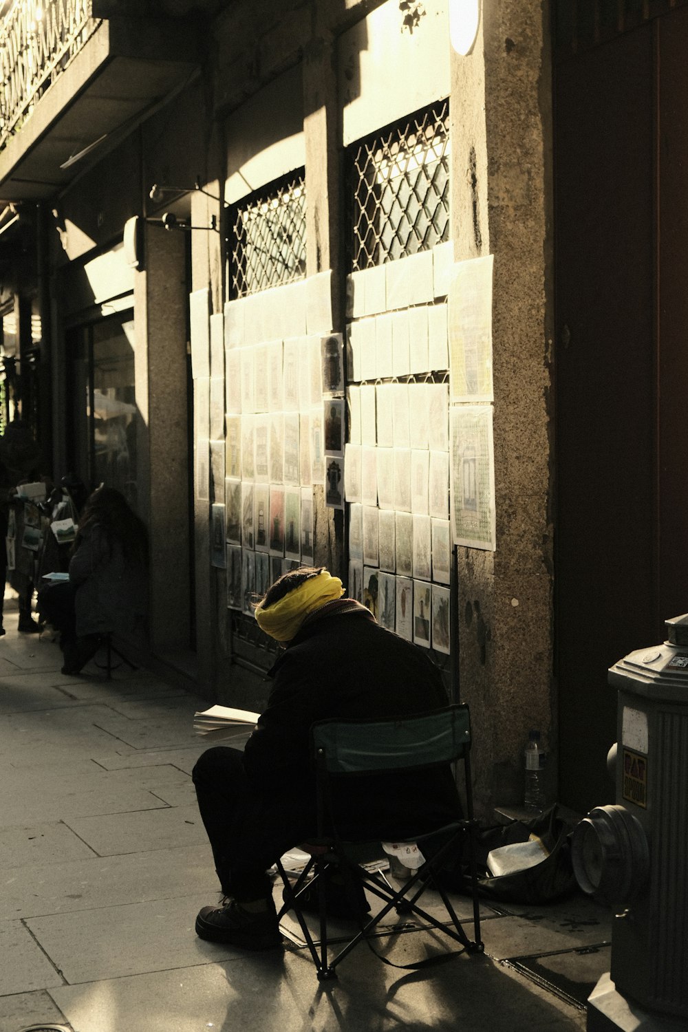 a man sitting in a chair on a sidewalk